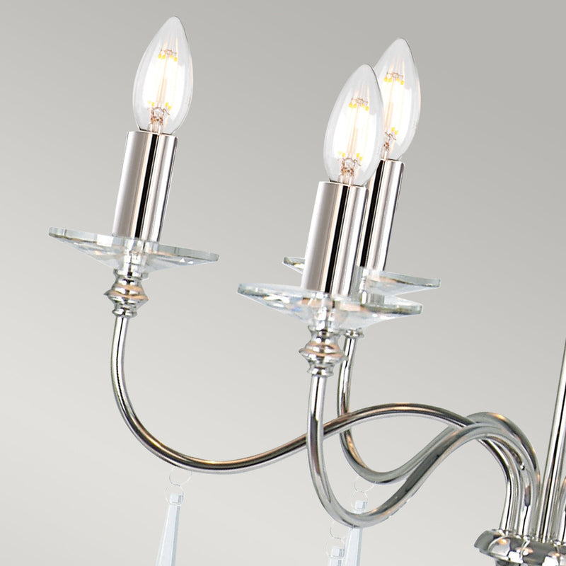 The Elstead Finsbury Park six-light chandelier finished in polished nickel, is a stunning traditional chandelier, with graceful upswept curved arms. Heavy-cut clear glass sconces, hand-cut glass drops, and matching candle tubes complete this classic light fitting. 