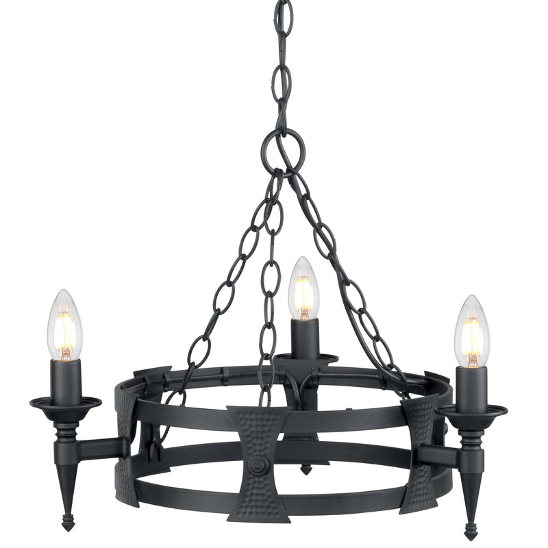This Elstead Saxon matt black wrought iron 3 light cartwheel chandelier has two metal bands for the cartwheel rim, with hand-crafted beaten shields decorating the outer rim. Each of the three torchière light arms is mounted on a shield and features tapered finials and forged metal candle pans. It is all suspended from three chains attached to a central chain hanging from a circular ceiling mount.